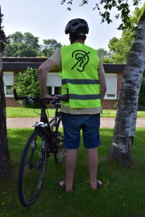Mann mit Fahrrad von hinten mit Fördervereinsweste