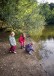 Drei Kinder spielen am Teich