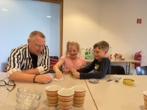 Schuleiter spielt mit 2 Kindern Karten